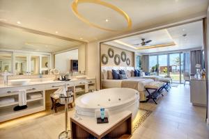 a bathroom with a tub and a bedroom with a bed at Royalton Riviera Cancun, An Autograph Collection All-Inclusive Resort & Casino in Puerto Morelos