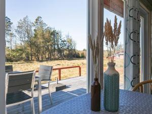 eine Vase auf einem Tisch auf einer Veranda in der Unterkunft 6 person holiday home in Oksb l in Oksbøl