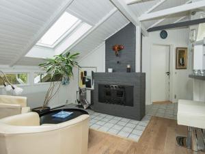 - un salon avec une cheminée et un canapé dans l'établissement 6 person holiday home in Oksb l, à Oksbøl