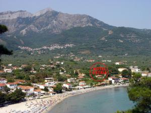 een uitzicht op een strand met een bord en bergen bij Ostria Hotel in Skala Potamias