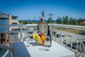 a table with glasses and a bowl of fruit on a balcony at Villa Morfeas in Paralia Katerinis