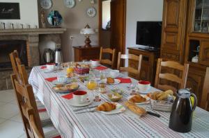 a table with a breakfast of croissants and orange juice at Chambres d'Hôtes La Loubatais in Dol-de-Bretagne