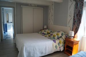 a bedroom with a bed and a window and a door at Chambres d'Hôtes La Loubatais in Dol-de-Bretagne