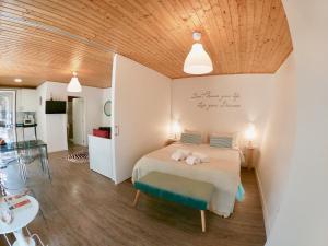 a bedroom with a bed with two stuffed animals on it at Golden Halcyon - Ericeira Villas in Ericeira
