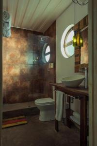 a bathroom with a toilet and a sink and a mirror at Hotel Winebox Valparaiso in Valparaíso