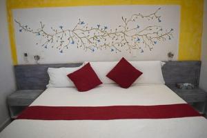 a bedroom with a bed with red and white pillows at Villa Mont in Cuernavaca