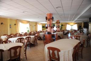 a dining room with tables and chairs with white table cloth at Hotel Gran Duca in Briatico