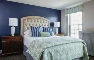 a bedroom with a large bed with blue walls at Farmer's Creekside Tavern & Inn in Le Roy