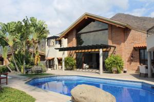 a swimming pool in front of a house at Hotel Lindo Ajijic Bed & Breakfast in Ajijic