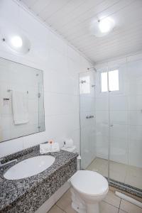 y baño con aseo, lavabo y ducha. en Hotel Express Canoas, en Canoas