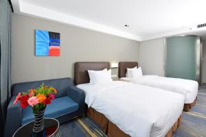 a hotel room with two beds and a blue couch at Holiday Inn Express Changchun High-Tech Zone by IHG in Changchun +19 photos
