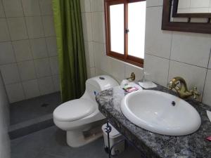 ein Badezimmer mit einer weißen Toilette und einem Waschbecken in der Unterkunft Hostal Bivouac in La Paz