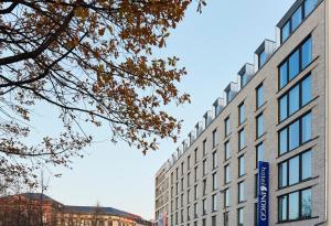 a building with a sign on the side of it at Hotel Indigo Dresden - Wettiner Platz by IHG in Dresden