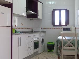 a kitchen with white cabinets and a washing machine at CASA SAN ANTÓN in Arcos de la Frontera