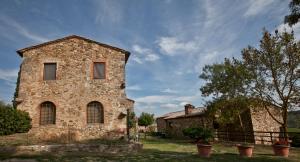 an old stone building with windows on a field at Agriturismo il Torrione in Poggibonsi