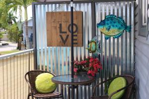 a table and chairs on a balcony with a fish sign at Latitude 26 Waterfront Boutique Resort - Bonita Springs in Bonita Springs