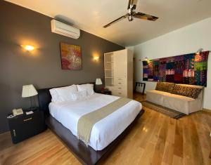 a bedroom with a large white bed and a couch at Hotel Villa Condesa in Mexico City