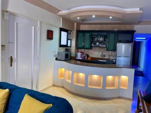 uma cozinha com armários verdes e um balcão azul em Seaside Two-Bedroom Chalet Sidi Krir em Sidi Krir