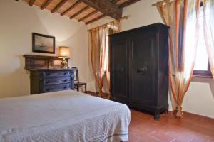 1 dormitorio con 1 cama, armario y ventana en Agriturismo il Torrione en Poggibonsi