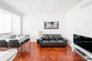 リスボンにあるCentral Family and Executive Apartmentのリビングルーム(黒いソファ、テーブル付)