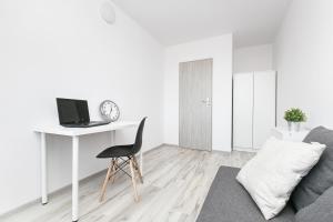 a white living room with a desk and a chair at Rooms4Less in Gdańsk