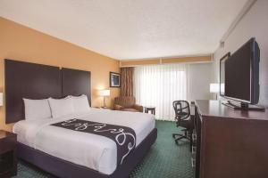 um quarto de hotel com uma cama, uma secretária e uma televisão em La Quinta Inn by Wyndham Berkeley em Berkeley