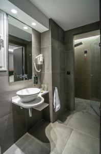 een badkamer met een wastafel en een douche bij Palmyra Beach Hotel in Athene