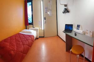 Habitación hospitalaria con cama y escritorio con ordenador portátil en Premiere Classe Nancy Est Essey, en Essey-lès-Nancy
