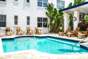 a swimming pool with chairs and a hotel at Blue Moon Hotel in Miami Beach