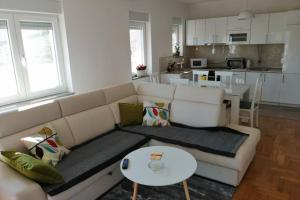 a living room with a white couch and a table at Sun garden apartment in Trebinje