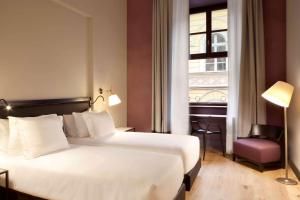 a hotel room with a bed and a window at NH Collection Torino Piazza Carlina in Turin