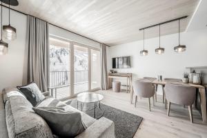 sala de estar con sofá y mesa en Alpenstern Panoramalodge en Damuls
