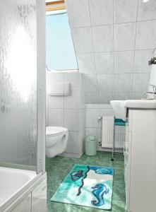 ein Badezimmer mit Waschbecken, WC und Teppich in der Unterkunft Insel-Idyll Sonnenschein in Insel Poel