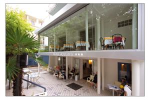 a building with a patio with tables and chairs at Hotel Azzurro in Cattolica
