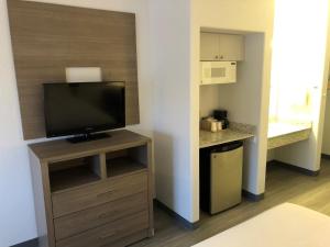 a room with a flat screen tv on a stand at GreenTree Inn Denver Tech Center in Centennial