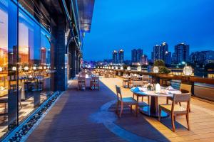 a balcony with tables and chairs and a city skyline at Holiday Inn Neijiang Riverside, an IHG Hotel in Neijiang