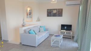ein Wohnzimmer mit einem weißen Sofa und einem TV in der Unterkunft Sea View Private Pool Villa in Astrakeri