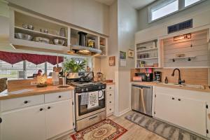 a kitchen with white cabinets and a stove top oven at Coastal Escape with Yard - Walk 1 Mile to Texas AandM! in Corpus Christi