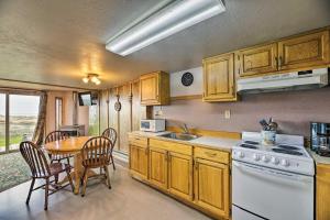 a kitchen with a table and a white stove top oven at Sanderling Sea Cottages, Unit 2 Walk to Coast! in Waldport