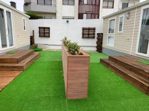 a garden with wooden benches and green grass at Villa Granja Sol in São Félix da Marinha