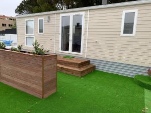 a backyard with a deck and a house with green grass at Villa Granja Sol in São Félix da Marinha
