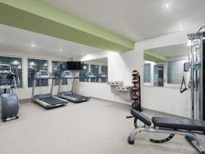 una palestra con diversi tapis roulant e macchine in una stanza di WoodSpring Suites Fort Worth Forest Hill a Forest Hill