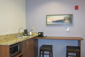een hotelkamer met een wastafel en een aanrecht met krukken bij Quality Inn & Suites in Caldwell
