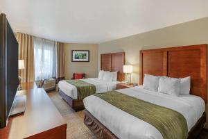 a hotel room with two beds and a flat screen tv at Comfort Inn University in Missoula