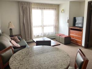 a living room with a table and a couch and a tv at Snowshoe Motel in Frisco