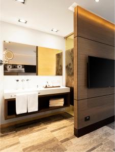 a bathroom with a sink and a flat screen tv at EK Hotel By Preferred Hotels Group in Bogotá