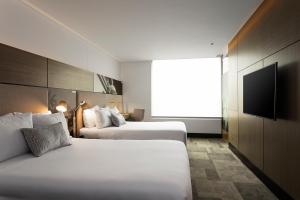 ボゴタにあるEK Hotel By Preferred Hotels Groupのベッド2台と薄型テレビ付きのホテルの部屋