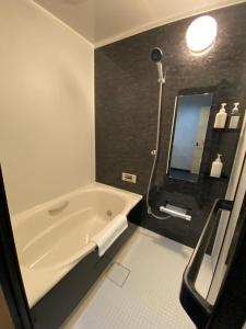 a bathroom with a bath tub and a mirror at ZEN CHALETS Hakuba in Hakuba +126 photos