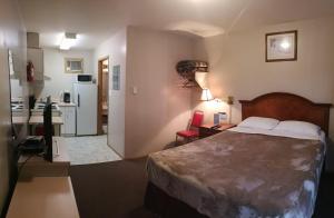 a hotel room with a bed and a kitchen at Ranchland Villa Motel in Merritt