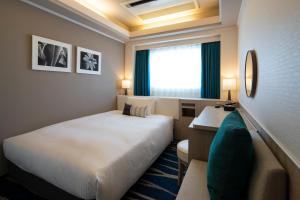 a hotel room with two beds and a window at Shin Yokohama Grace Hotel in Yokohama
